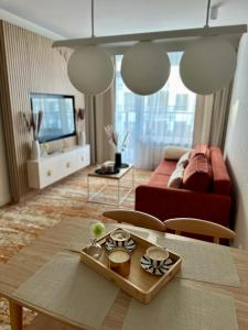 a living room with a table and a couch at Belmare Bursztynowy Zakątek in Międzyzdroje