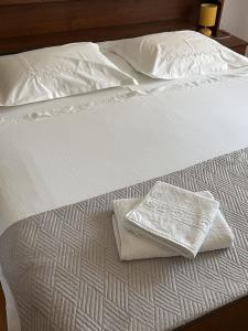 a white bed with two white towels on it at Apartment Simi in Postira