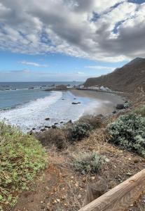 a view of a beach with a wooden fence at Apartamento junto al mar El Roque in Santa Cruz de Tenerife +7 photos