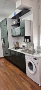 una cucina con lavatrice e lavandino di Door to 5 terre a La Spezia