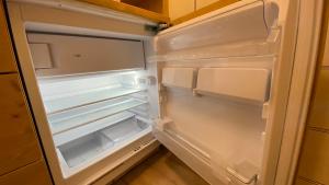 an empty refrigerator with its door open in a kitchen at Il Cadorino in Valle di Cadore