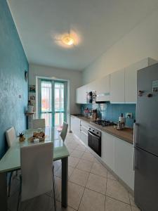 a kitchen with a table and a refrigerator and a dining room at B&b Bamby in Turin