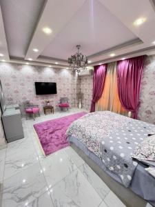 - une chambre avec un grand lit et des murs roses dans l'établissement الشيخ زايد, à Sheikh Zayed