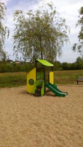 a playground with a green slide in a park at Pescalis Résidence Les Maisons du Lac in Moncoutant