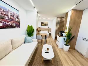 a living room with a white couch and a table at Lois Apartment in Tirana