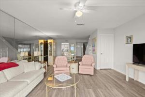 Una sala de estar con un sofá blanco y sillas rosas. en Green Palms Oceanfront 2 Bed Townhouse, en Ponce Inlet