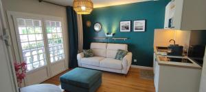 a living room with a white couch and a chair at Studio Le Balcon du Béarn in Livron