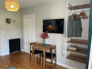 a dining room with a table and a coat hanging on a wall at Studio Le Balcon du Béarn in Livron