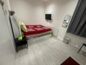 a small hospital room with a red bed in it at Y2 guest house in London