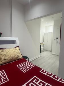 a bedroom with a bed with a red and white bedspread at Y2 guest house in London