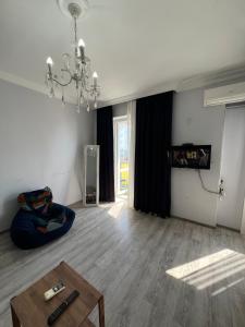 a living room with a coffee table and a chandelier at Апартаменты Зура 3 in Batumi