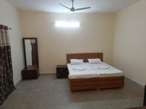 una camera da letto con un letto e un ventilatore a soffitto di shri gokerneswar guesthouse a Jaipur Altre 22 foto