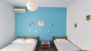 two beds in a room with a blue wall at Pansion Galini in Therma +59 photos