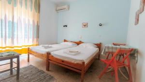 a bedroom with a bed and a chair in it at Pansion Galini in Therma