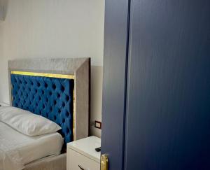 a bedroom with a blue door and a bed at Central- AZURE -Stay in Përmet