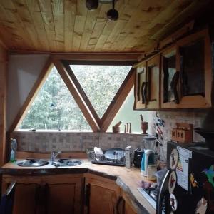 a kitchen with a sink and a window in it at CABAÑA DOMO EN VILLARICA TERRADOMOS AFUNALHUe in Nalcahue +26 photos