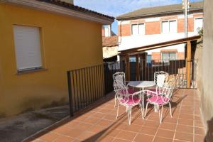 un patio con 4 sillas y una mesa en el balcón en Casa Dobón, en Castralvo