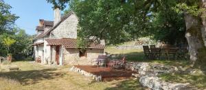 a stone house with a picnic table in front of it at Marmite et traversin in Cénevières