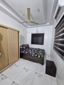 a room with a bed and a ceiling fan at Séjour Élégant à Agoè in Komé