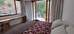 Un dormitorio con una cama y un escritorio y una ventana. en Amed Mountain View, en Amed