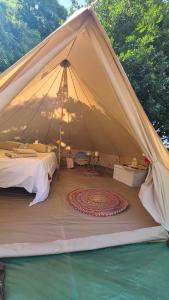 a tent with a bed and a rug in it at Nuit insolite tente Grandi'Ose proche Mont Saint Michel in Le Ferré