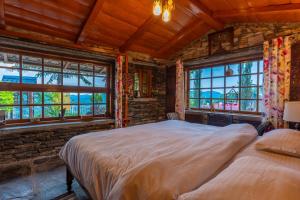 穆克缇斯瓦Stone Heritage Mukteshwar的一间带窗户的房间里有两张床的卧室