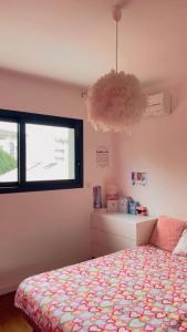 a bedroom with a bed and a window and a chandelier at Le soleil de pessac in Pessac