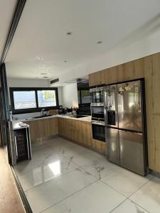 a large kitchen with a stainless steel refrigerator at Le soleil de pessac in Pessac