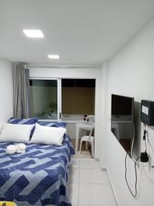 una camera con un letto blu e bianco e un tavolo di Flat Sol e Mar Residence Porto de Galinhas PE a Porto De Galinhas Altre 32 foto