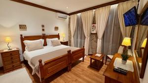 um quarto com uma cama, uma escrivaninha e janelas em Quinta de CasalMato em Resende mais 37 fotografias