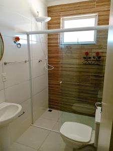 a bathroom with a toilet and a glass shower at Pousada das Colinas in Águas de Lindóia +276 photos