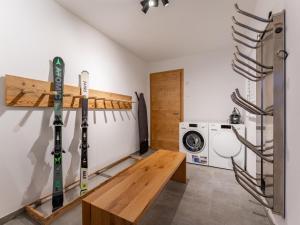 een kamer met ski's aan een muur naast een wasmachine bij Tauernlodge Eben A3 in Eben im Pongau