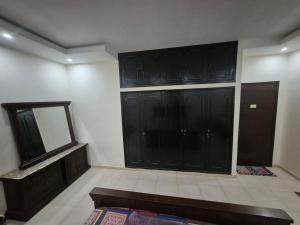 a large room with black cabinets and a mirror at Budget Hostel Rooms in Al Ain