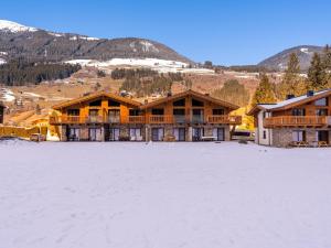 een groot gebouw in de sneeuw voor een berg bij Tauernlodge Eben A3 in Eben im Pongau