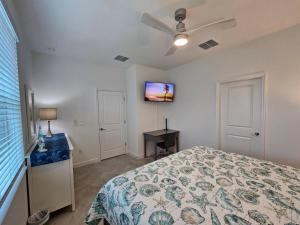 ein Schlafzimmer mit einem Bett und einem Fernseher an der Wand in der Unterkunft Close to Englewood and Boca Grande beach, monthly New Vacation Villa in Englewood