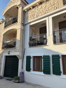 a building with green shutters on the side of it at House Sela vrata in Bibinje