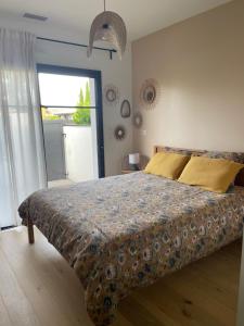 a bedroom with a bed and a large window at Charmante chambre chez l habitant in La Teste-de-Buch