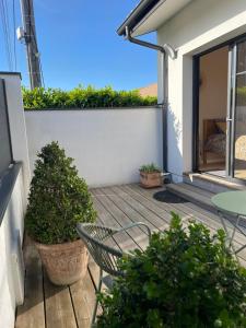 a patio with a chair and a table and plants at Charmante chambre chez l habitant in La Teste-de-Buch