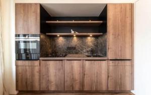 een keuken met houten kasten en een spoelbak bij Santer Klause in Merano