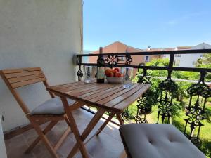 鲍希茨Apartments Skipper bay Baosici的阳台上的木桌,有一碗水果