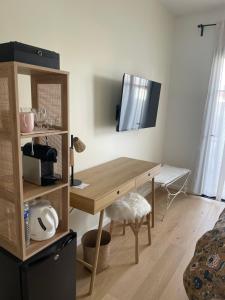 a room with a desk with a television on the wall at Charmante chambre chez l habitant in La Teste-de-Buch