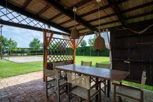 a wooden table and chairs under a pavilion at Resort Tenuta La Rotta - Rooms & Pool in Ravenna