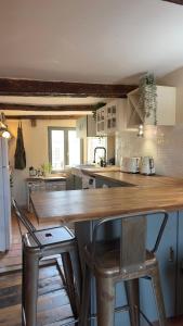 a kitchen with a wooden counter and chairs in it at Duplex, jacuzzi, terrasse sur les toits in Nice