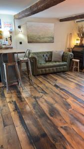 a living room with a couch on a wooden floor at Duplex, jacuzzi, terrasse sur les toits in Nice