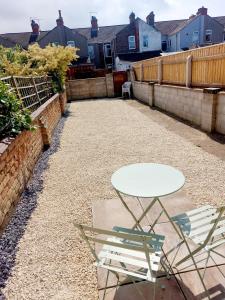 a patio with a table and chairs and houses at Stunning 2 Bed House, Cleethorpes - Contractors Welcome! in Cleethorpes
