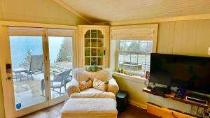 sala de estar con TV, silla y sofá en Serenity Lake House, en Palms