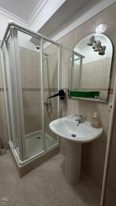 a bathroom with a shower and a sink and a mirror at Blue haven guest house in Caniço +23 photos