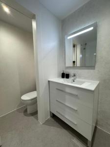 a bathroom with a white sink and a toilet at Apartamentos en la rambla in Sant Feliu de Guíxols
