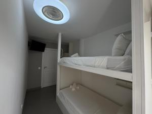 a bedroom with a bed with a light on the ceiling at Apartamentos en la rambla in Sant Feliu de Guíxols +13 photos