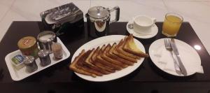 a table with a plate of food with bread and toast at Cloud 7 Hotel Gulberg in Gulberg